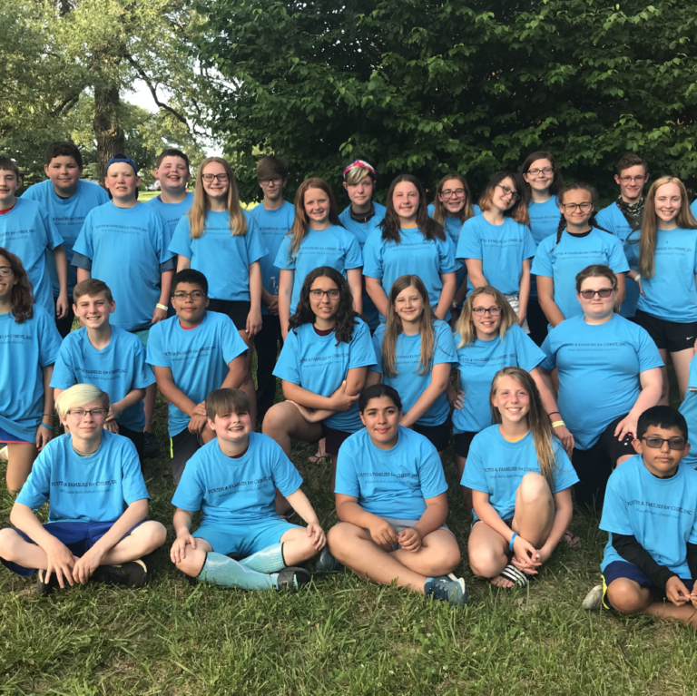 Group of kids wearing blue shirts taking part in the Youth for Christ Summer Camp