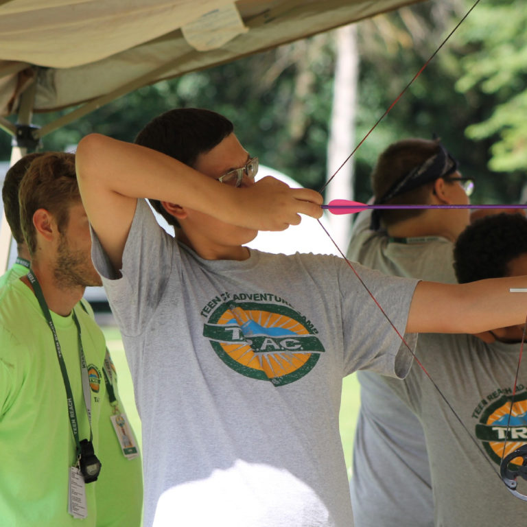 Teen boys practice archery as part of Teen Reach Adventure Camp